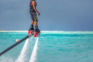 water extreem sport, zomer zee en tropisch weer met buitenshuis actief mensen genieten van water sport. vlieg bord, surfing in oceaan, pret en zomer recreatief werkzaamheid. flyboarden en zeerijden foto