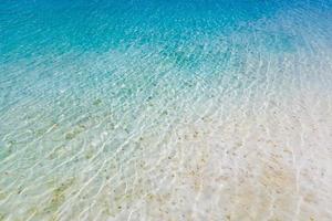 Doorzichtig water reflecties Aan Ondiep zanderig strand onderkant, zomer dag foto