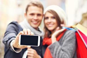 paar boodschappen doen in de stad met smartphone foto