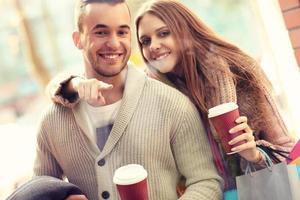 jong paar met koffie boodschappen doen in de winkelcentrum foto