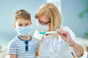 kinderarts dokter onderzoeken weinig kinderen in kliniek covid test foto