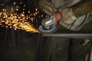 vonken van slijpen staal. Mens werken in garage. metaal behandeling. foto