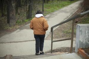 meisje gaat naar beneden trap. vrouw wandelingen door park. wandelen langs pad. foto