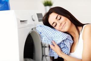 portret van jong huisvrouw met wasserij De volgende naar het wassen machine foto