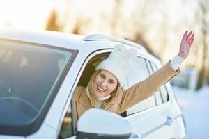 gelukkig vrouw het rijden auto in besneeuwd winter foto