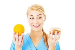 verpleegster Holding zoet voedsel en oranje over- wit achtergrond foto