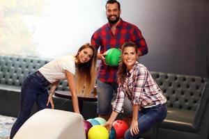 groep van vrienden spelen bowling foto