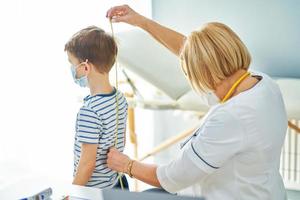 kinderarts dokter onderzoeken weinig kinderen in kliniek meten plakband foto