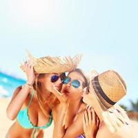 twee Dames zoenen vriend Aan de strand foto