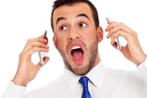woedend zakenman pratend Aan twee telefoons foto