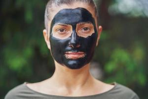 jong vrouw in natuur met zwart masker Aan gezicht foto