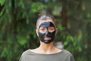 jong vrouw in natuur met zwart masker Aan gezicht foto