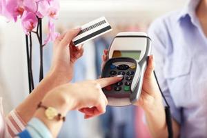 detailopname midden sectie van vrouw klant betalen in winkel met credit kaart foto
