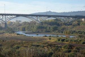 modern brug overspannende een rivier, een bouwkunde prestatie foto