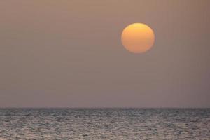 zonsondergang en zonsondergang Aan de zee foto