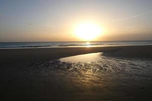 zon instelling over- de zee, zonsondergang in herfst Aan de strand van zahara de los stemt af, cadiz, Andalusië, Spanje foto