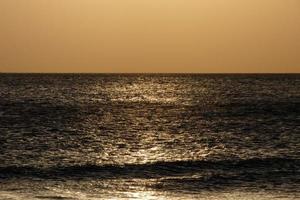 zon instelling over- de zee, zonsondergang in herfst Aan de strand van zahara de los stemt af, cadiz, Andalusië, Spanje foto