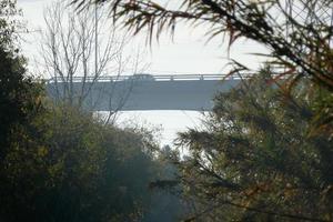 modern brug overspannende een rivier, een bouwkunde prestatie foto