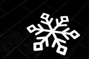 wit papier sneeuwvlok Aan zwart achtergrond, kopiëren ruimte. foto