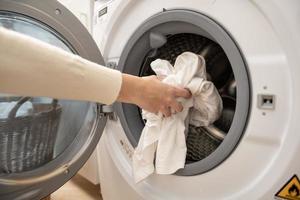 detailopname vrouw hand- is houden kleren in het wassen machine , Gezondheid zorg levensstijl concept foto