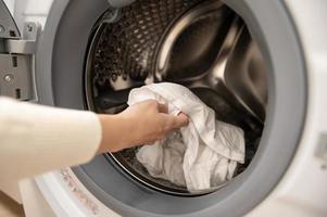 detailopname vrouw hand- is houden kleren in het wassen machine , Gezondheid zorg levensstijl concept foto