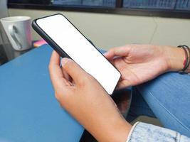 detailopname van een vrouw hand- Holding een smartphone wit scherm is blanco .model. foto