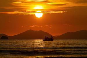 varen in de zee met golven en lucht, gouden zon foto