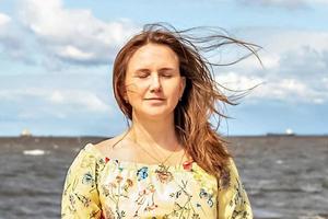 een groot portret van een jong vrouw met fladderend haar- in de wind Aan de kust foto