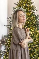 een jong vrouw met blond haar- met een Kerstmis boom. nieuw jaar begrip, kerstmis decoraties foto