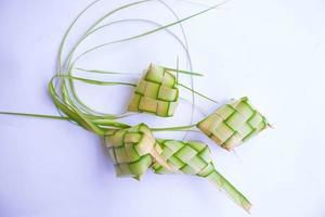 ketupat in aardewerk bord geïsoleerd Aan wit achtergrond. ketupat rijst- knoedel is voedsel geserveerd wanneer idhul fitri eid mubarak in Indonesië, gemaakt van rijst- verpakt in jong kokosnoot bladeren janur foto