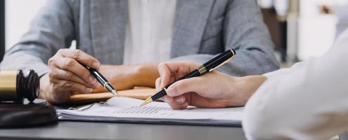 rechtvaardigheid en recht concept.male rechter in een rechtszaal met de hamer, werken met, computer en docking toetsenbord, brillen, op tafel in ochtendlicht foto