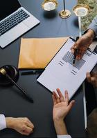 rechtvaardigheid en recht concept.male rechter in een rechtszaal met de hamer, werken met, computer en docking toetsenbord, brillen, op tafel in ochtendlicht foto