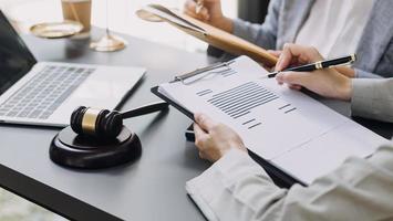 zaken en advocaten bespreken contractpapieren met koperen schaal op bureau in kantoor. wet, juridische diensten, advies, rechtvaardigheid en wet concept foto met film grain effect