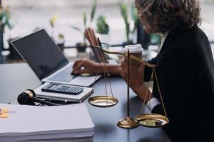 mannelijke advocaat die met contractdocumenten en houten hamer op tafel in rechtszaal werkt. justitie en recht, advocaat, rechter, concept. foto