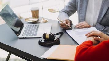 wet boeken en balans van gerechtigheid Aan bureau in bibliotheek van wet stevig. jurisprudentie wettelijk onderwijs concept. foto