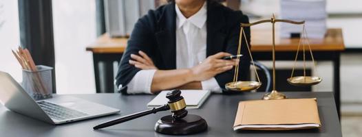 mannelijke advocaat die met contractdocumenten en houten hamer op tafel in rechtszaal werkt. justitie en recht, advocaat, rechter, concept. foto