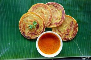 paratha brood of canai brood of roti maryam, favoriete ontbijt gerecht. geserveerd Aan banaan vertrekken foto