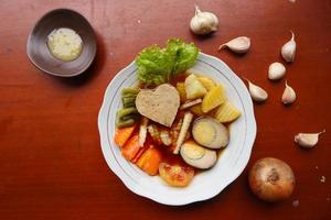 selat solo is traditioneel salade voedsel van Indonesië. gemaakt van hard gekookt eieren, gekookt kikkererwten, gekookt wortels, hasj bruin en sla, steak of bistik. geserveerd Aan hout tafel foto