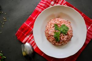 rood gestoomd rijst- of nasi merah geserveerd in bord geïsoleerd Aan zwart achtergrond foto
