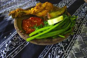 nasi tempong of sego tempong is traditioneel voedsel van banyuwangi, Indonesië gemaakt van rijst, traditioneel gebakken inktvis, gebakken aubergine, komkommer plakjes, groenten, spinazie en pittig sambal Chili foto