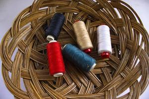 naaien draad, spoel van draad met een naald- in mand geïsoleerd Aan wit achtergrond foto