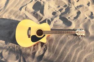 gitaar akoestisch met achtergrond zand strand in vakantie foto