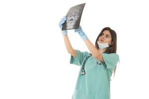 jong vrouw dokter op zoek Bij de röntgenstraal afbeelding. geïsoleerd Aan wit foto