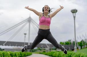 sport- vrouw jumping van vreugde tot oefening. foto