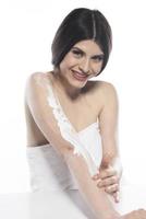 mooi huid vrouw toepassen lichaam lotion Aan wit achtergrond foto