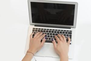 handen typen Aan een laptop Aan een kantoor bureau. bedrijf concept foto