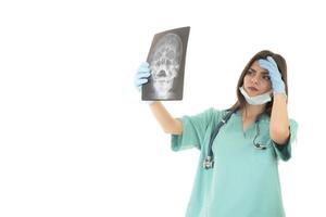 jong vrouw dokter op zoek Bij de röntgenstraal afbeelding. geïsoleerd Aan wit foto