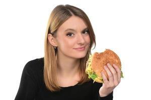 portret van een mooi grappig jong meisje aan het eten Hamburger. foto