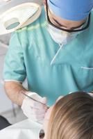 tandarts genezen patiënten tanden vulling holte. tandarts werken met professioneel uitrusting in kliniek. foto