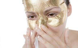 kunstmatig procedure, de vrouw gezicht met goud masker Aan wit achtergrond foto